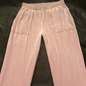 Juicy Couture byxor rosa - Byxor från Juicy Couture, använda kanske 5ggr. Köpta från Kids brand store. Byxorna är i storlek 15/16år. Men passar som S/M storlek. Jag brukar ha stolek S och de är lite stora för mig. Hade passat bra någon som har storlek M om man vill ha de tajta annars passar de någon som har stolek S.