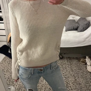 Beige stickad tröja med knytningar  - Säljer en beige stickad tröja med lång ärm och snygg snörningsdetalj i sidorna. Storlek s/m passar båda❤️