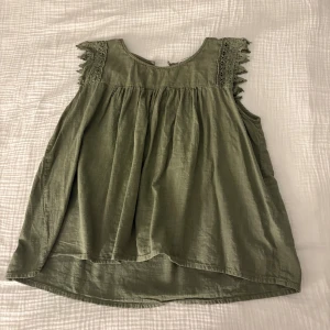 Grön topp - En jättefin grön topp med fina detaljer vid axlarna. Använd ett fåtal gånger 
