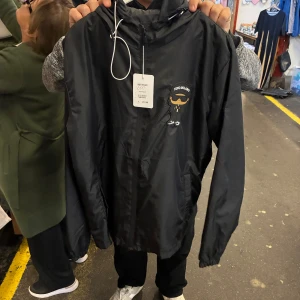 Svart vindjacka från Vino Milano - Svart vindjacka med huva från Vino Milano. Priset kan diskuteras vid snabb affär