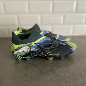 Puma fotbollsskor i blå och neon (model Puma future 7 ultimate) storlek 42 - Säljer ett par helt nya Puma Future 7 Ultimate. Skorna är aldrig använda, helt i nyskick storlek 42