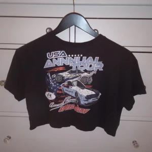 Croppad t-shirt med tryck  - Croppad t-shirt med ett bil tryck på ( den är väl använd och de syns på trycket 