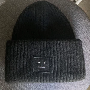 Svart Acne mössa - Svart acnemössa med vita detaljer i acnemärket. Supersnygg nu till vintern. Väldigt sparsamt använt så i mycket bra skick🥰
