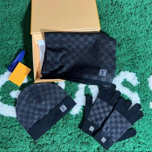 Louis set - Snygg halsduk från Louis Vuitton i svart och grått med klassiskt rutigt mönster och diskret LV-logga. Halsduken är mjuk och passar perfekt till kyliga dagar. Matcha med mössa och handskar för en komplett look.