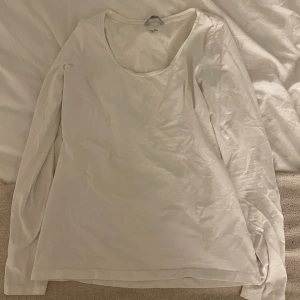 Vit långärmad tröja från H&M - En basic vit långärmad tröja från H&M i mjuk bomull. Tröjan har rund halsringning och en enkel, clean design som passar till allt. Perfekt att styla lager på lager eller bära som den är.