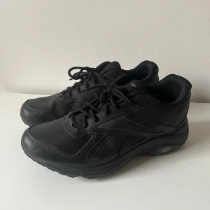 Svarta Reebok sneakers  - Svarta sneakers från Reebok med klassisk design. Reebok-logga på hälen och sidan. Strl 45.