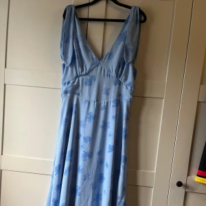 Ljusblå långklänning med blommor - Superfin ljusblå långklänning med blommigt mönster och djup v-ringning både fram och bak. Säljer den då den inte passade mig 🌸