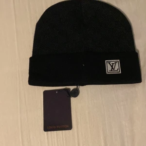 Svart mössa  - Svart mössa Klassisk och stilren design i mjukt material som passar perfekt för kalla dagar. Mössan har en diskret struktur och exklusiv känsla, perfekt för dig som vill ha något lyxigt och tidlöst.