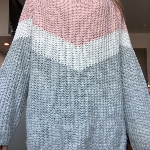 Stickad tröja i pastellfärger  - Supermysig stickad tröja med breda block i ljusrosa, vitt och ljusgrått. Tröjan har lång ärm, loose fit och är  bred, något offshoulder ringning. Perfekt för lager-på-lager och chill dagar.