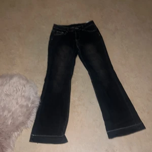 Svarta bootcut jeans med kontrastsömmar - Snygga svarta jeans med bootcut passform och vita kontrastsömmar. Klassisk femficksmodell med knapp och dragkedja i midjan. Jeansen har en lätt utsvängd benvidd och är tillverkade i ett mjukt denimtyg som sitter skönt hela dagen. Pris kan diskuteras 