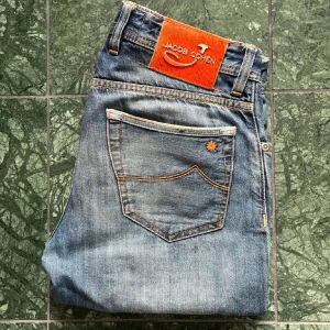 Jacob cohën Limited edition 622 W30 - Måten: A, 39 cm B: 100 cm. Modellen är 180,75 kg och skulle säga passar honom bra lite tighta i waisten. Finns en liten defekt på benet där det är ett litet märke men inget som tänks på. Vet ej om jag ska vara ärlig om det orangea liksom har fallit ut ur loggan. Tror dock inte det men har med det ifall. Kan lösa fler bilder! see less