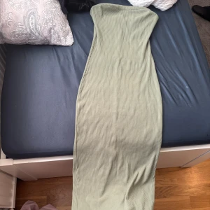 Ljusgrön ribbad axelbandslös klänning  - Säljer en ljusgrön, ribbad långklänning som är axelbandslös. Klänningen har en tight passform 