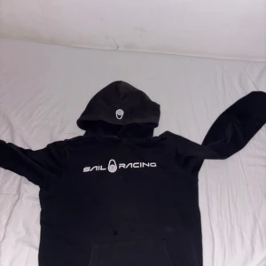 Svart Sail Racing hoodie  - Säljer nu en svart sail racing hoodie!!! Som är perfekt nu inför vintern att ha något under din jacka! Hoodien passar även till S storleken! Dma mig om du vill köpa den!! Priset kan även diskuteras!😎