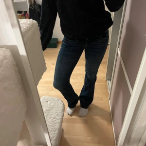 Mörkblå bootcut jeans - Säljer ett par mörkblå LTB valerie jeans med bootcut-modell och klassisk femficksdesign. Storlek 27/32. Jeansen har låg midja och är tillverkade i ett stretchigt denimtyg som sitter snyggt över höfterna och låren. Perfekta för dig som gillar en tidlös och avslappnad look. 