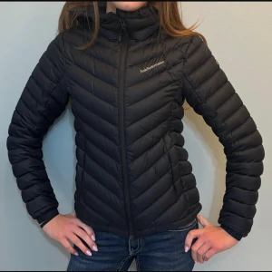 Svart dunjacka från Peak Performance - Säljer en svart dunjacka från Peak Performance med huva och dragkedja framtill. Skriv vid frågor!