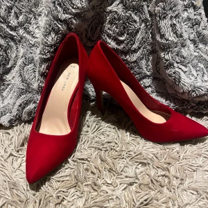 Klack skor - Snygga röda pumps från New Look i storlek 39. Skorna har spetsig tå och hög klack, tillverkade i ett mockaliknande material som ger en lyxig känsla. Perfekta för dig som vill sticka ut med en färgstark look.