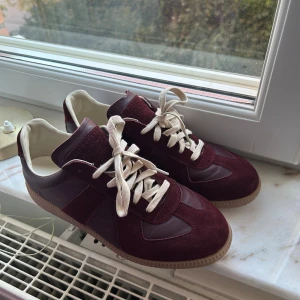 Mörkröda Maison Margiela Gats - Säljer dessa sjukt snygga gats, de är i fint skick, en defekt (fläck på ena skon, går säkert att ta bort) och storlek 43, priset kan vi diskutera om det innebär en snabb affär!✨(skolåda med tillbehör medföljer vid köp)