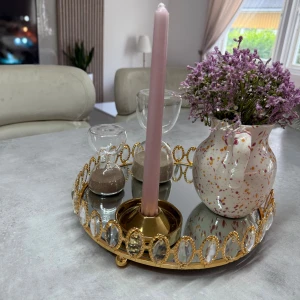 Dekoration bricka  - Bilderna visar ett dekorativt bricka med spegelbotten och guldfärgad ram prydd med kristall-liknande dekorationer. Brickan är rund och står på små fötter. Perfekt för smycken, parfym eller som elegant inredningsdetalj. Skicket ser utmärkt ut utan synligt slitage eller defekter.