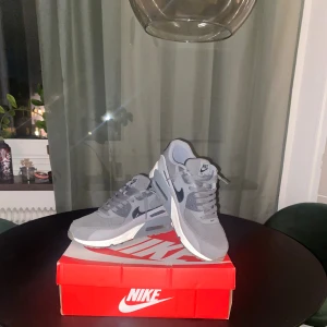 Nike Air Max 90 grå sneakers - Säljer dessa feta air max 90 då jag inte använder de så ofta. Haft de i någon månad men använd någon enstaka gång. Skick 9/10 storlek 42.  Det är bara att skriva vid intresse. Pris kan absolut diskuteras vid snabb affär