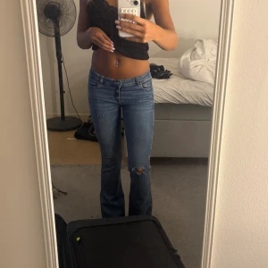Blå bootcut jeans med slitningar - Sjukt snygga jeans från Gina, har klippt hålen själv. Säljer då jag köpt nya jeans och dessa tyvärr inte används längre.❣️Sitter perfekt på mig som är 1,65-1,66❣️
