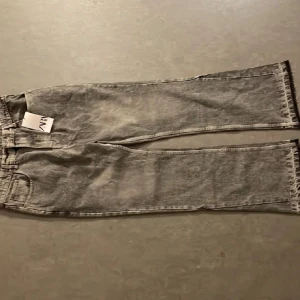Grå straight jeans från Zara, stl M - Säljer ett par grå tvättade straight fit jeans från Zara i storlek M (40/31). Jeansen har klassisk femficksdesign, bälteshällor och raka ben. Materialet är denim i bomull och färgen är snyggt stentvättad grå. Perfekta för en chill och stilren look.