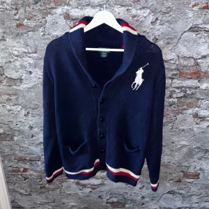 Stickad Ralph Lauren cardigan - Mycket fint skick, inga defekter. Storlek XL junior sitter som S ungefär. passar dig som är mellan 170-180 typ. Nypris ca 2000kr. Modellen är 185 cm, 79 kg. Passar bra nu till vintern. Skriv för mer information!🤝