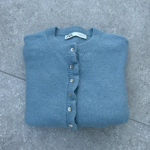 Blå kofta med volang från Zara - Blå kofta från Zara med volangdetaljer. Jättebra skick och knappast använd. Storlek M.