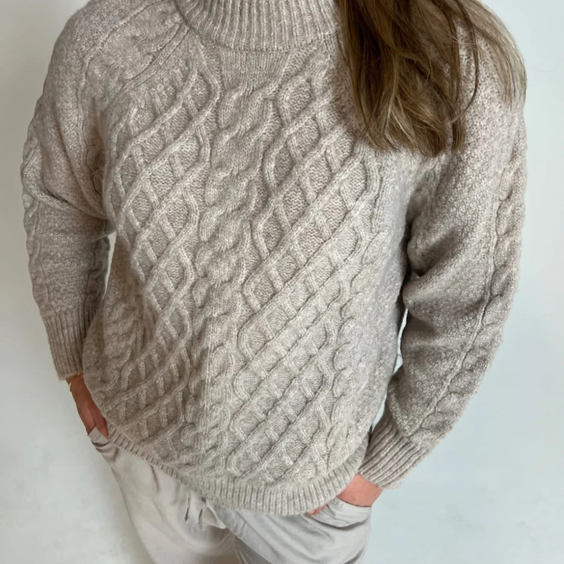 Beige stickad polotröja med flätmönster