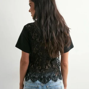 Svart t-shirt med spetsrygg - En snygg T-shirt med unik spets rygg 😍 Tröjan är från Nelly med prislapp kvar 💗 Säljer då den för liten och hann inte lämna tillbaka 🥰