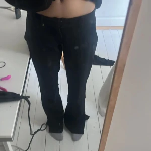 Svarta bootcut byxor från BikBok - Säljer ett par svarta bootcut byxor från BikBok i storlek 34. Byxorna har slits nertill vid benslut och sitter snyggt i midjan. Materialet är mjukt och stretchigt, perfekt för en trendig look. Passar dig som gillar stilrena och moderna byxor.