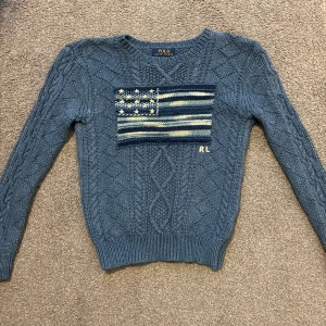 Ralph Lauren Flag Tröja - Säljer denna ikoniska och väldigt sällsynta ralph lauren tröja med USA flagga på|Den är grovsticad med USA flaggan och RL broderi | Barnstorlek. Passar XS | Givetvis äkta | Skicket är 9/10 | Mått: Bredd: 40cm Totallängd: 56cm Ärmlängd: 50 | Priset ej hugget i sten vid snabbt köp  