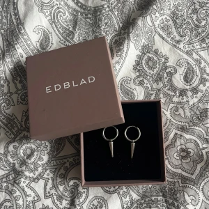 Örhängen Edblad - Silvriga örhängen från Edblad. De är använda men har inga defekter. Jag kommer desinfektera dem innan jag skickar! Nypris 399kr! Kolla gärna in mina andra annonser för samfrakt och ett bra paketpris!