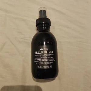 Davines OI All In One Milk spray - NÄSTAN 90% KVAR!! En svart sprayflaska med Davines OI All In One Milk, 135 ml. Produkten är en multifunktionell hårbehandling som gör håret glansigt, mjukt och silkeslent. Innehåller roucouolja och passar alla hårtyper. Nypris ca 389.