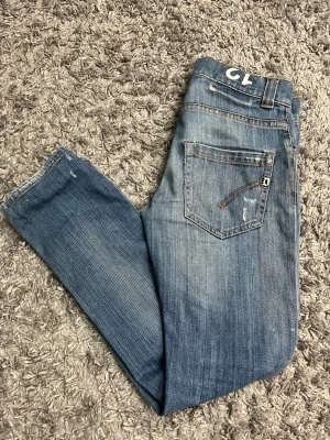 Blå slitna jeans från Dondup Lucky - Snygga blå jeans från Dondup Lucky med slitningar och distressed detaljer på benen. Klassisk femficksmodell med raka ben och normal passform. Passar dig som är runt 155-165. Perfekt för dig som gillar en cool och avslappnad stil. Pris kan diskuteras
