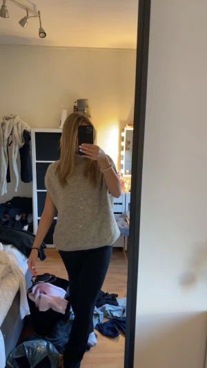 Beige stickad med polokrage - Säljer en beige stickad med polokrage utan ärmar. Den har en loose passform och är ribbstickad både vid kragen och nederkanten. Den är från NAKD i storlek S och sticks inte!💞