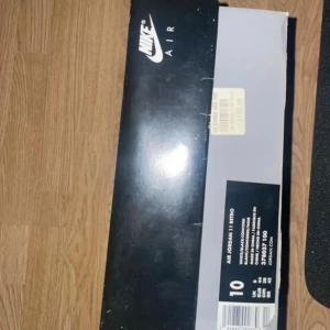 Nike Air Jordan 11 Retro white/black - Nike Air Jordan 11 Retro sneakers in white and navy with classic Jumpman logo on the side and the number 45 embroidered on the heel. The shoes have laces, flat sole and a combination of leather and synthetic materials. Comes with original box and purple shoe block with Jumpman