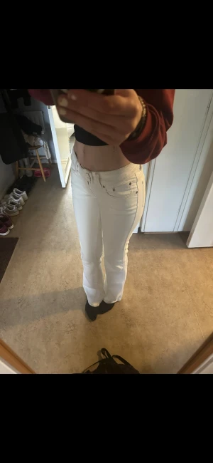 Vita bootcut jeans med broderad ficka - Snygga vita jeans med bootcut passform och låg midja. Storlek S Tall (85cm innerben) Byxorna har dubbla knappar i midjan, klassiska fickor och ett broderat mönster på bakfickan. Perfekta för dig som vill sticka ut med en fräsch och stilren look. Köpa för 400kr💕 Kan mötas i sthlm o pris kan diskuteras 💗