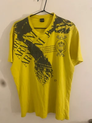 Armani Jeans tshirt M - Gul armani jeans thsirt med stort tryck på framsidan. Andvänd ett par gånger