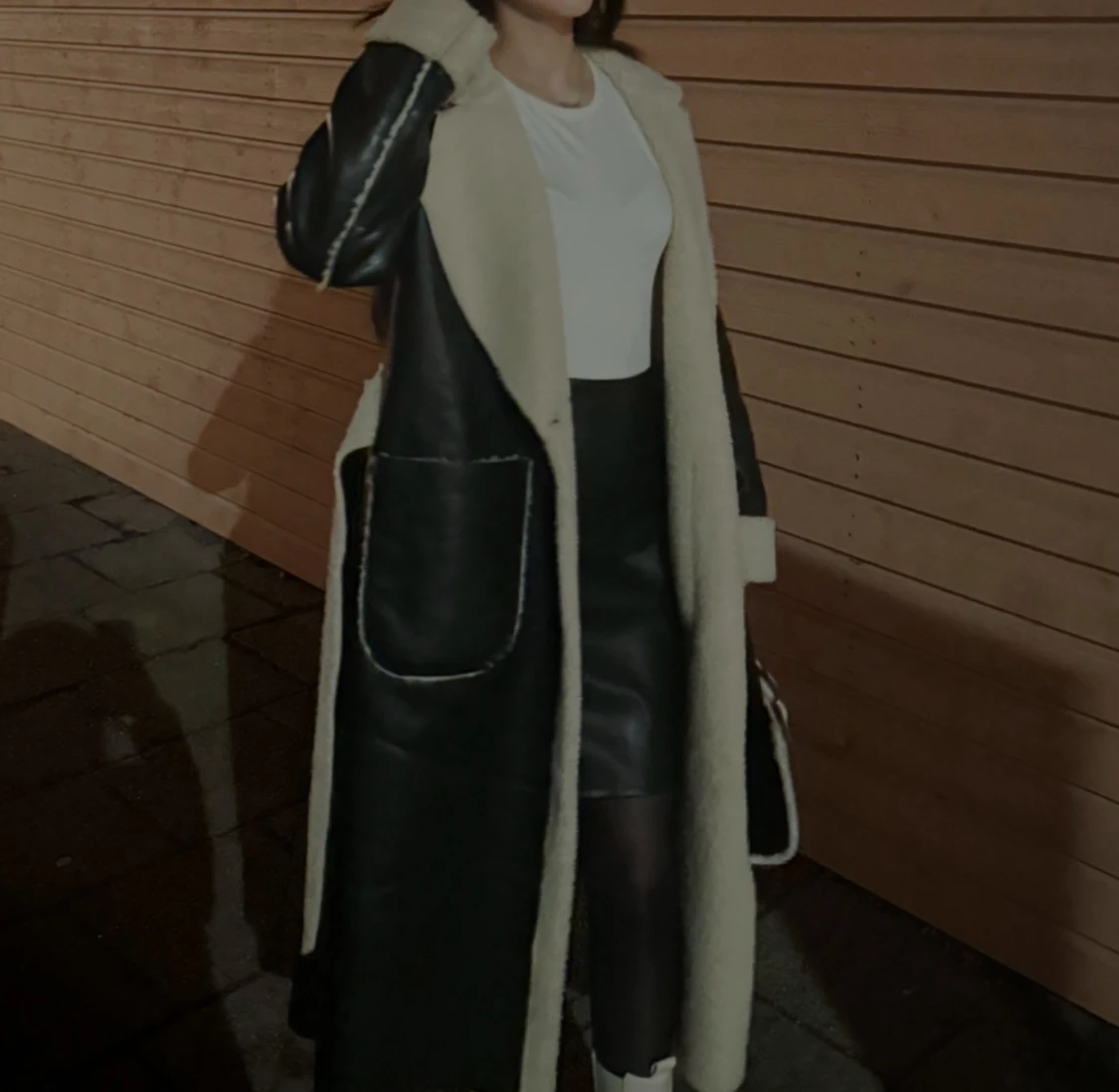 Lång svart pälsjacka med vita detaljer