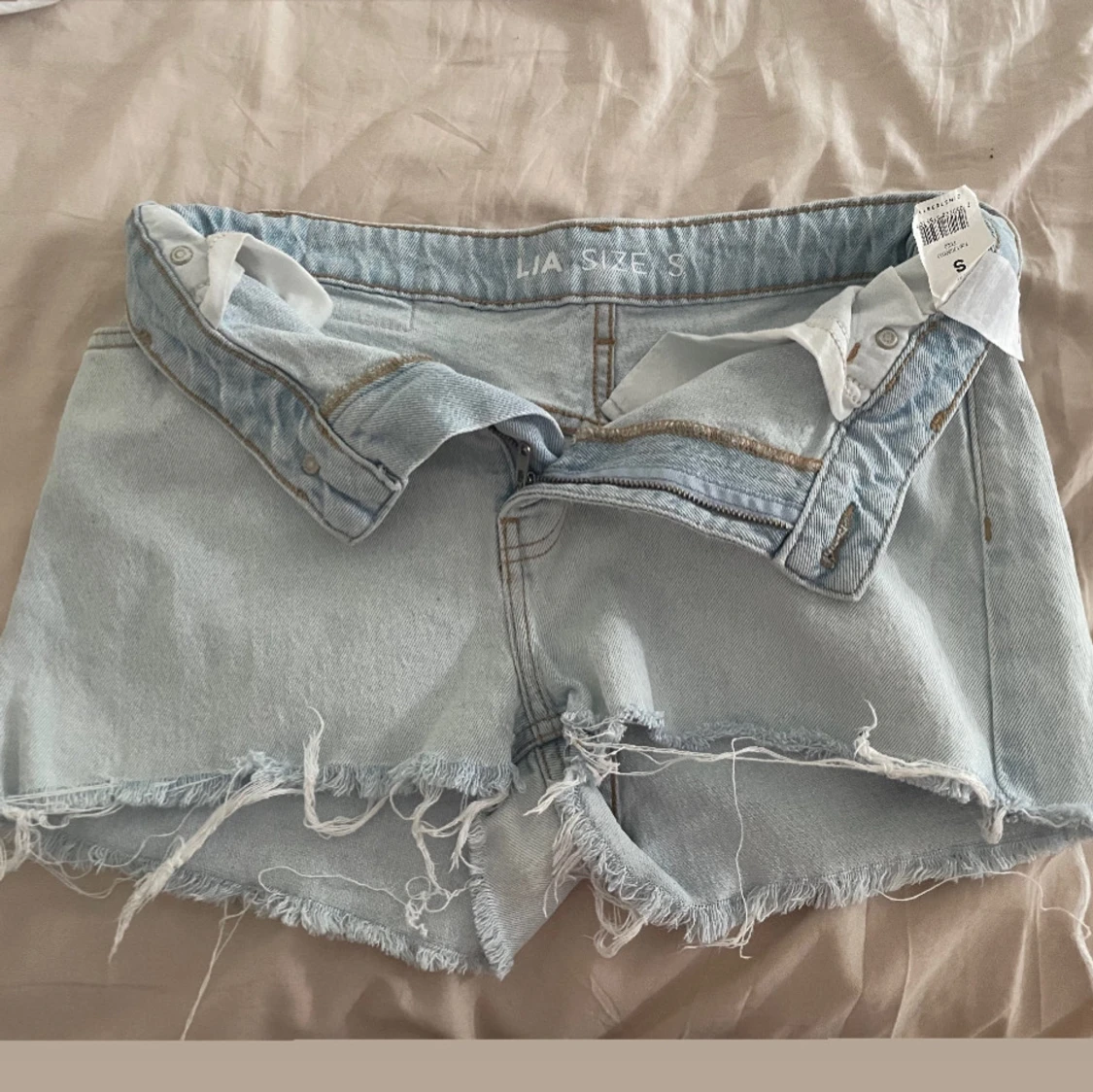 Ljusblå jeansshorts med fransig kant