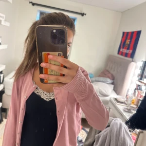 Rosa kofta med knappar - Säljer en söt rosa kofta med knappar framtill. Koftan har långa ärmar och ribbade muddar vid ärmslut. Perfekt att slänga över en topp för en chill och snygg look.