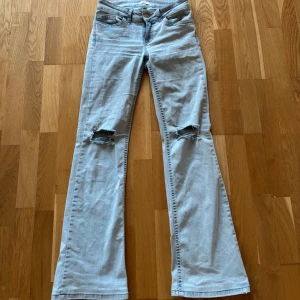 Ljusblå bootcut jeans med slitna knän - Säljer ett par ljusblå jeans med bootcut passform och slitna hål på båda knäna från nelly. Skriv för bild på!
