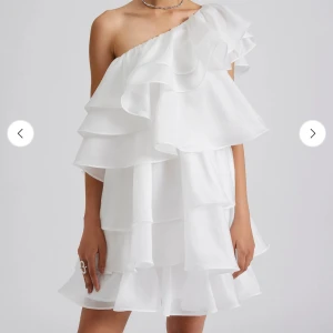 Vit by Malina volang klänning  - Superfin vit kortklänning i märket By Malina med flera lager volanger och oneshoulder-skärning! Nypris 3800kr