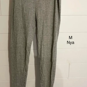 Grå leggings i storlek M - Grå leggings i mjukt och stretchigt material, perfekta för chill dagar eller när du vill vara extra bekväm. Byxorna har en enkel och stilren design utan synliga detaljer och sitter skönt på kroppen.