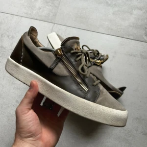 Giuseppe Zanotti 42 - Säljer ett par snygga sneakers från Giuseppe Zanotti i grön/grå mocka i mycket bra skick! Storlek 42. Skick enligt bilder
