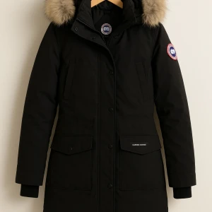 Svart parkas från Canada Goose - Svart parkasjacka från Canada Goose i modell Victoria Parka i storlek XS, passar även S!  Jackan har långa ärmar, dragkedja och knappar framtill samt praktiska fickor med lock. Jackan har justerbar midja samt äkta päls. Jackan är sparsamt använd under 1 vinter, inga defekter förekommer. Täcken på användning kan förekomma då blekning/slitning av färgen uppstår runt ex fickorna, vid kragen osv. Ingeting som är super tydligt eller påverkar användningen. Vänligen konakta mig vid frågor/önskemål!