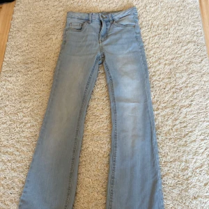 Ljusblå bootcut jeans från Kappahl - Snygga ljusblå jeans från Kappahl i storlek 146. Modellen har klassisk femficksdesign och bootcut-ben som ger en retrovibe. Jeansen är tillverkade i mjukt denimtyg och har normal passform med dragkedja och knapp framtill. 60kr med frakt!👍