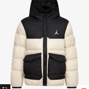 Jordan pufferjacka svart och beige - Säljer en snygg pufferjacka från Jordan i svart och beige med huva och stora fickor framtill. Jackan har dragkedja och den klassiska Jumpman-loggan på bröstet. Perfekt för kalla dagar och riktigt street-stil.  Använd få tal gånger använda en säsong!