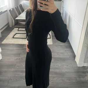 Svart ribbad långklänning - Säljer en svart långklänning med ribbad struktur och lång ärm. Klänningen har en slim passform som framhäver figuren och är tillverkad i ett stickat material som känns mjukt och skönt mot huden. Perfekt för dig som gillar stilrena och enkla plagg. Storlek är M och passar mig som har xs/s!