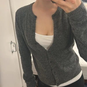 Mörkgrå stickad kofta med knappar - Mysig mörkgrå stickad kofta med rund halsringning och knäppning framtill.❤️